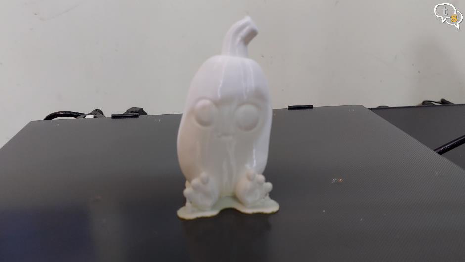 A small white figurine on a black surface Description automatically generated with low confidence