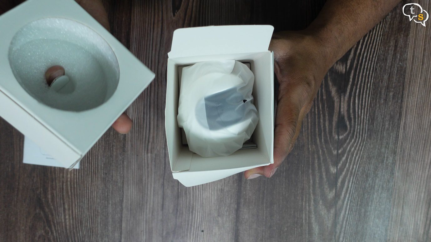 A hand holding a box with a roll of toilet paper Description automatically generated with low confidence