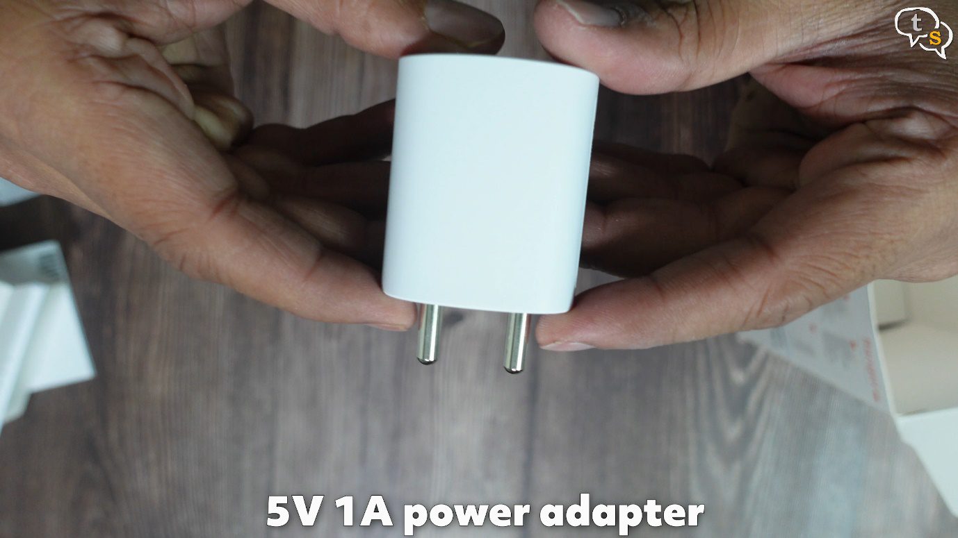 A person holding a power adapter Description automatically generated with low confidence